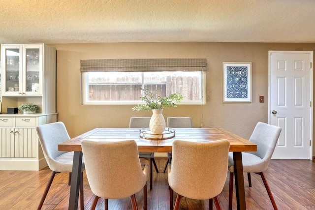 dining room with a textured ceiling and wood finished floors
