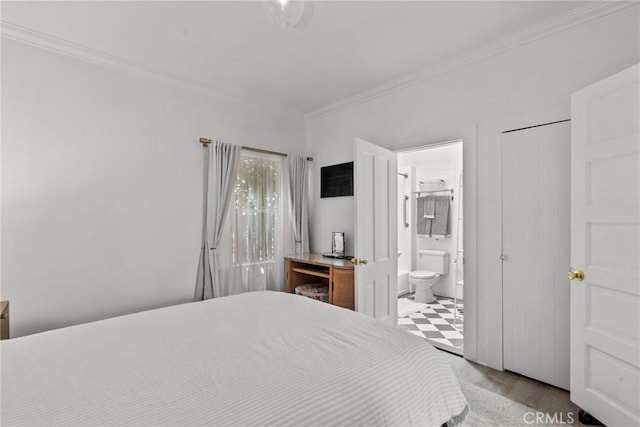 bedroom featuring ornamental molding, wood finished floors, and connected bathroom