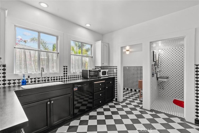 kitchen featuring a sink, dark cabinetry, white cabinets, white microwave, and dark floors