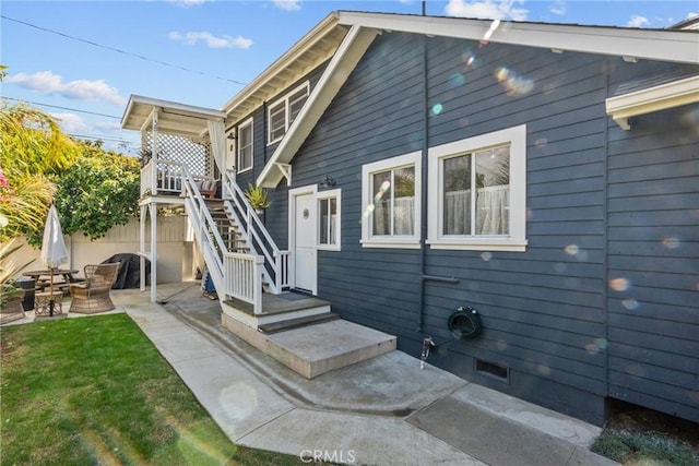 exterior space featuring stairs, a patio area, and a yard