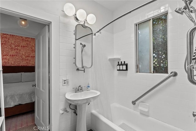 ensuite bathroom featuring shower / bath combination with curtain, a sink, and ensuite bathroom