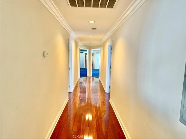 hall with crown molding, dark wood-style floors, baseboards, and visible vents