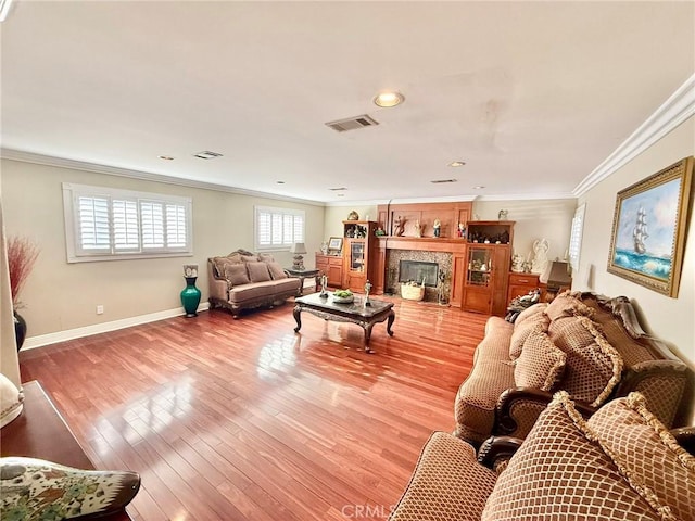 living room featuring baseboards, light wood-style floors, and ornamental molding