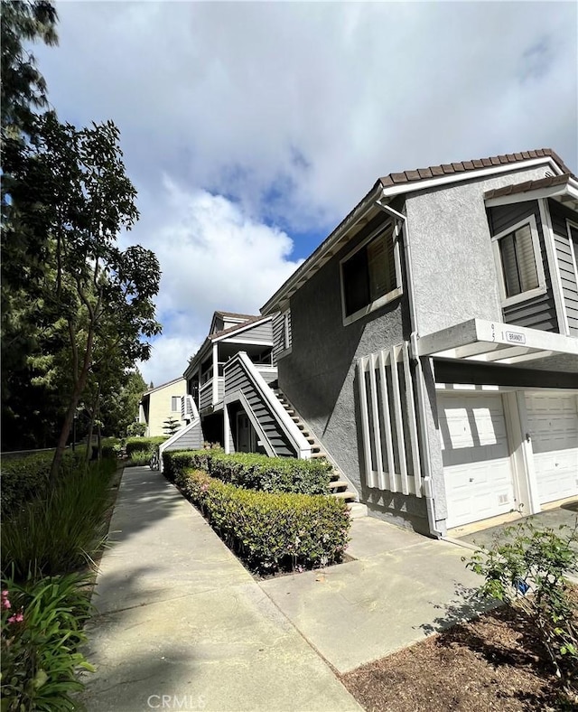 view of home's exterior with concrete driveway, stucco siding, and a garage