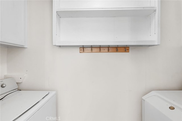 clothes washing area featuring cabinet space and washer / clothes dryer