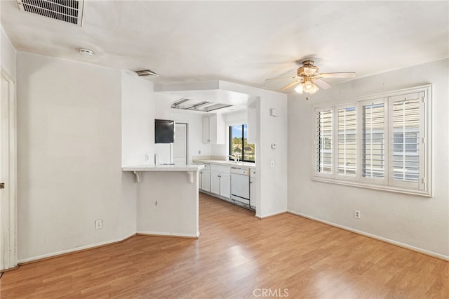 kitchen with light wood finished floors, light countertops, and dishwasher