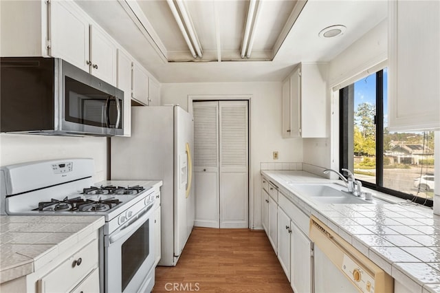 1 Brandy Ln Unit 23, Aliso Viejo, CA 92656 - kitchen with white appliances, a sink, tile counters, and light wood-style flooring