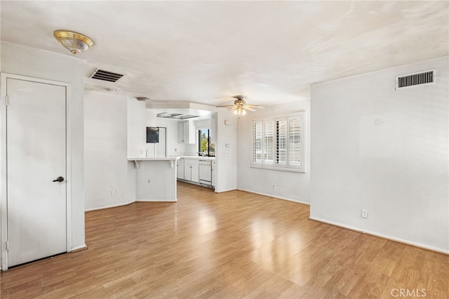 unfurnished living room featuring light wood-style floors, visible vents, and a ceiling fan