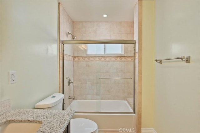 full bath featuring vanity, toilet, and bath / shower combo with glass door