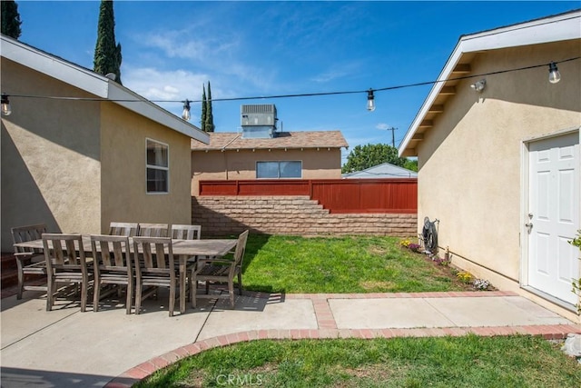 view of yard featuring a patio area, central air condition unit, outdoor dining area, and fence