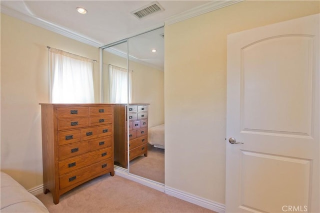 bedroom featuring a closet, visible vents, baseboards, ornamental molding, and light carpet