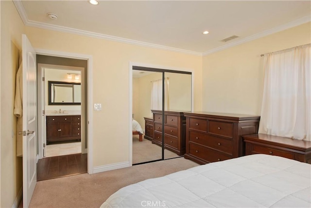 carpeted bedroom featuring crown molding, recessed lighting, baseboards, a sink, and a closet