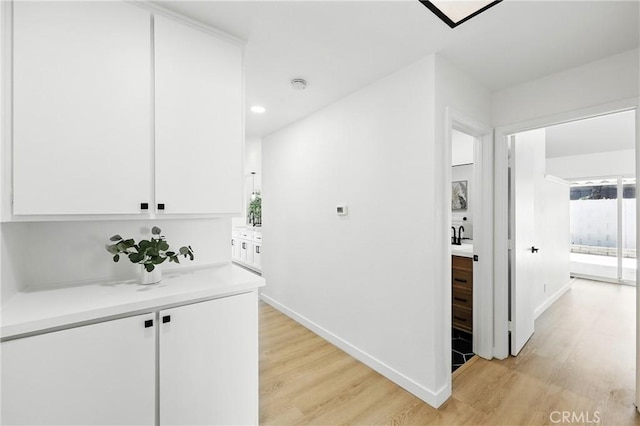 13538 Darvalle St, Cerritos, CA 90703 - corridor with recessed lighting, light wood finished floors, baseboards, and a sink