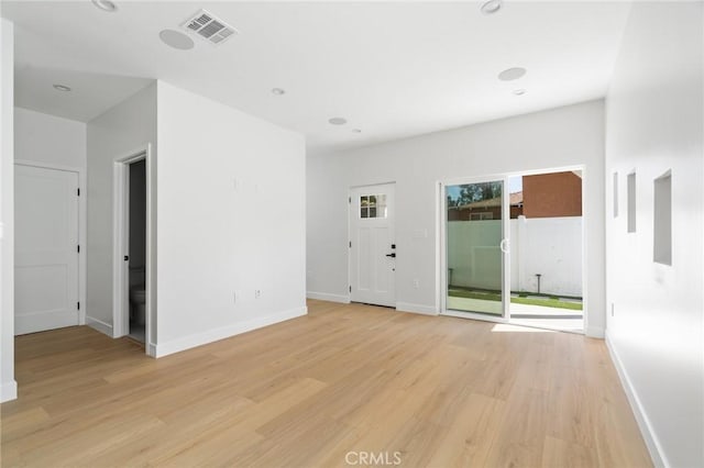 unfurnished living room featuring baseboards, light wood finished floors, and visible vents