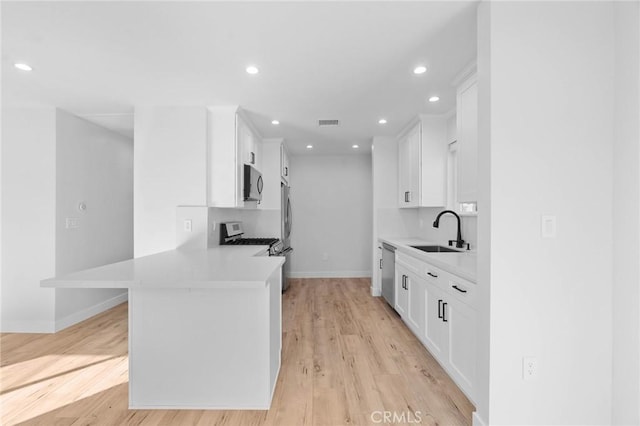 kitchen featuring a sink, appliances with stainless steel finishes, baseboards, and light countertops