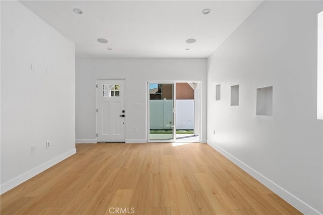 interior space featuring baseboards, recessed lighting, and light wood finished floors