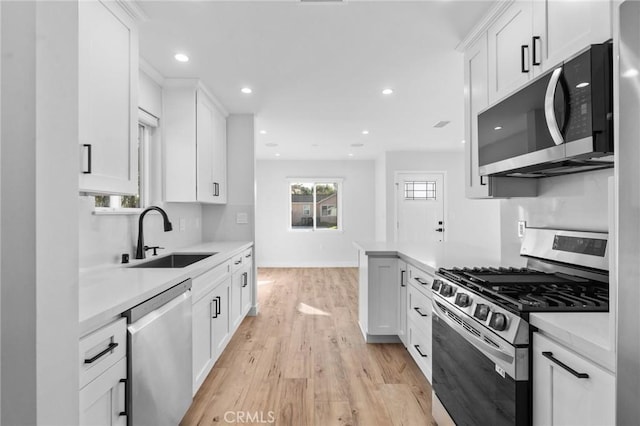 kitchen featuring a sink, light countertops, stainless steel appliances, and light wood finished floors