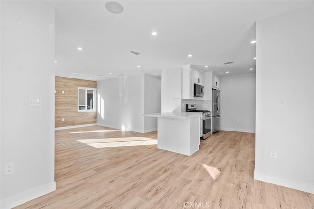 kitchen featuring baseboards, white cabinets, stainless steel appliances, and recessed lighting