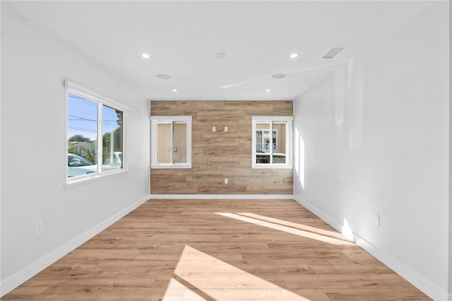 spare room with baseboards, light wood-type flooring, and recessed lighting