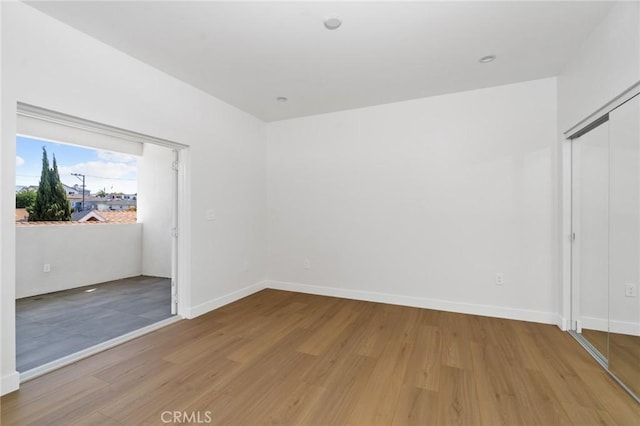 unfurnished bedroom with baseboards, a closet, and wood finished floors