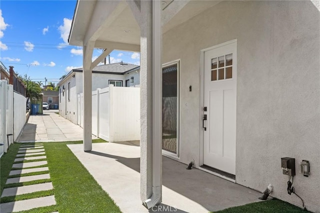 exterior space featuring fence, a patio area, and stucco siding