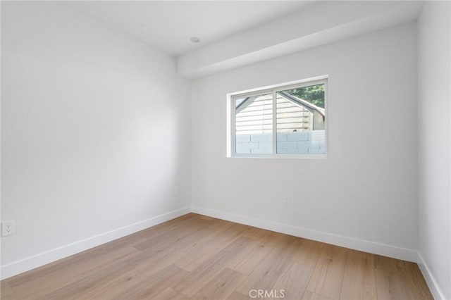 empty room featuring baseboards and light wood-type flooring