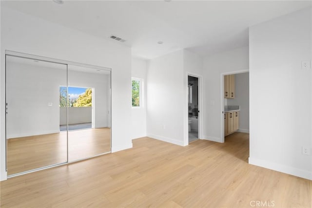 unfurnished bedroom featuring visible vents, light wood-style flooring, and baseboards
