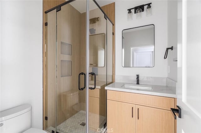bathroom with vanity, toilet, and a shower stall