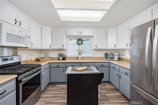 28861 Aloma Ave, Laguna Niguel, CA 92677 - kitchen featuring light wood-style floors, a center island, appliances with stainless steel finishes, light countertops, and gray cabinetry