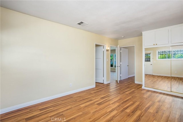 interior space with light wood finished floors, baseboards, and visible vents