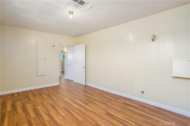 empty room featuring visible vents, baseboards, and wood finished floors