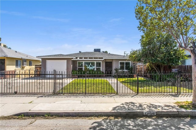 view of front facade featuring a front yard, a fenced front yard, a garage, stucco siding, and driveway