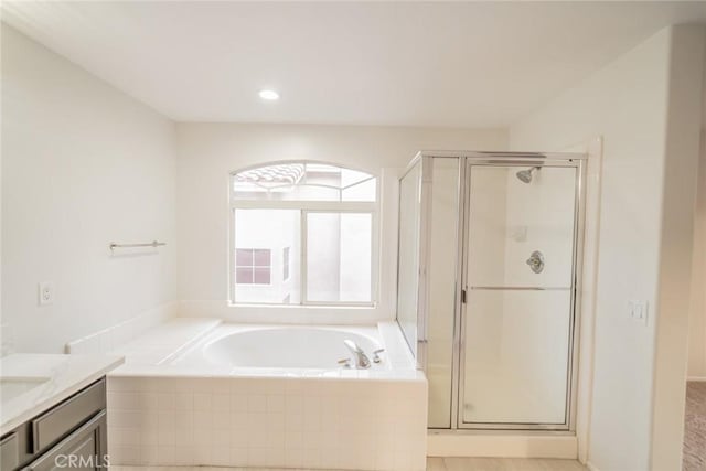 bathroom featuring a bath, a shower stall, and vanity