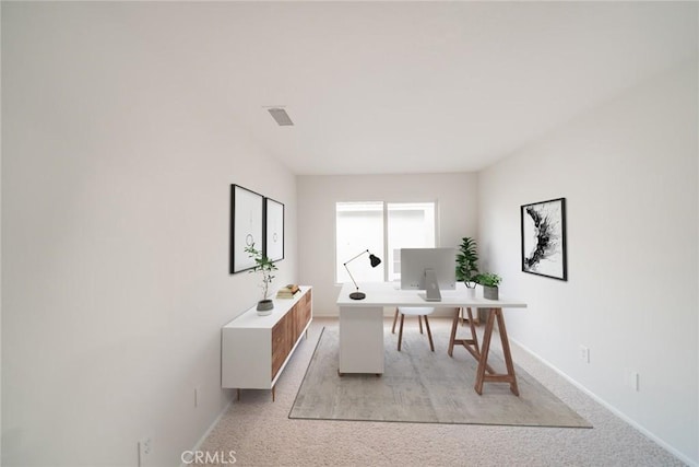 office area featuring visible vents, baseboards, and light colored carpet