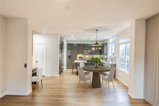 dining area featuring recessed lighting, light wood-style flooring, and baseboards