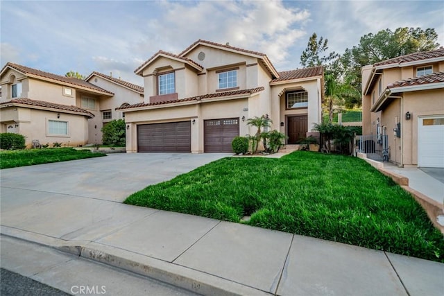 mediterranean / spanish-style house featuring stucco siding, driveway, a front yard, a tile roof, and a garage