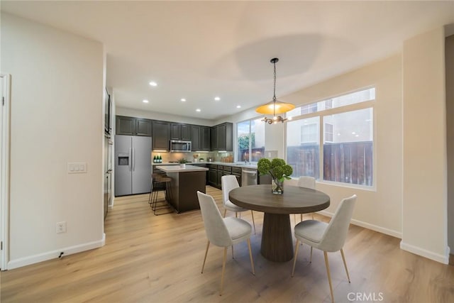 dining room with light wood-style flooring, recessed lighting, and baseboards