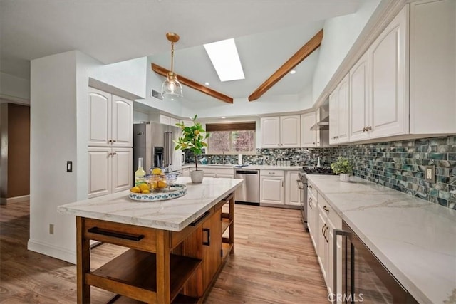 kitchen with a skylight, open shelves, premium appliances, light stone counters, and backsplash