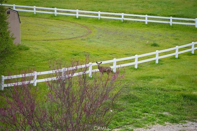 view of yard featuring fence and a rural view