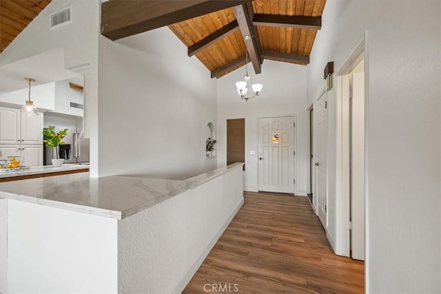 corridor with beam ceiling, wood ceiling, a chandelier, wood finished floors, and visible vents