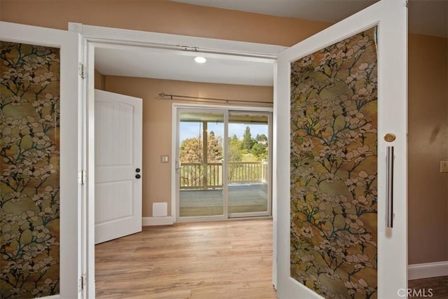 hall featuring baseboards and light wood finished floors
