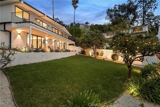 view of yard featuring a fenced backyard and a balcony