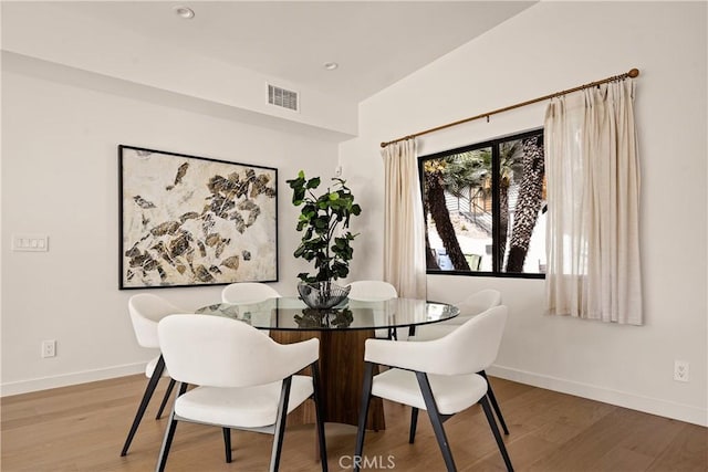 dining room featuring visible vents, baseboards, and wood finished floors