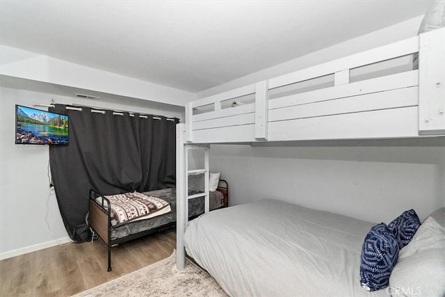 bedroom featuring baseboards, visible vents, and light wood-style floors