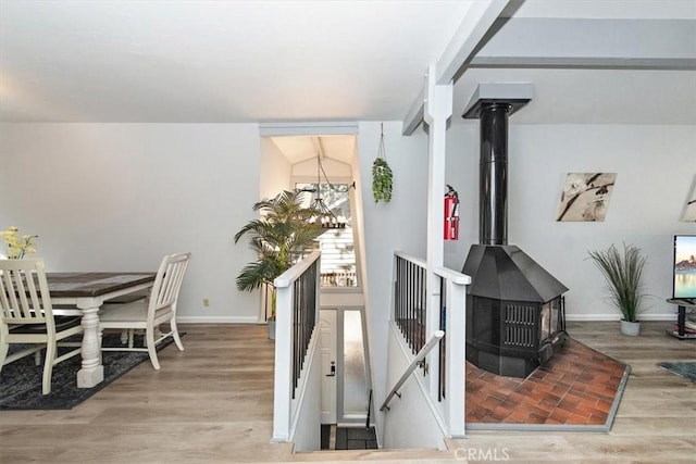dining room featuring baseboards, wood finished floors, and a wood stove