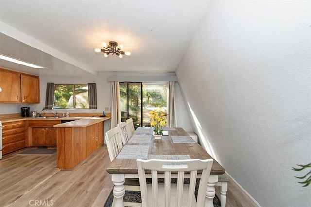 dining room with baseboards, a chandelier, and light wood finished floors