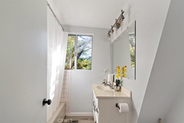 full bath with vanity, baseboards, shower / tub combo with curtain, and wood finished floors