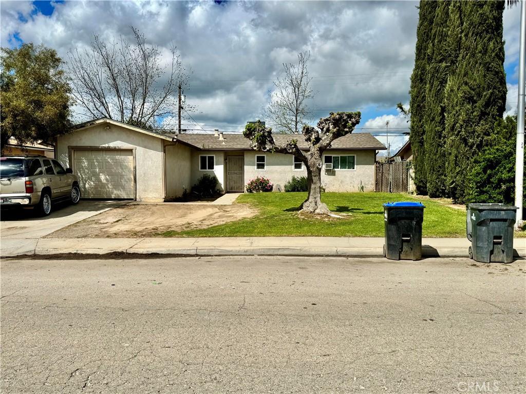 27139 Stanford Ave, Madera, CA 93637 - ranch-style home featuring concrete driveway, stucco siding, fence, a front yard, and a garage