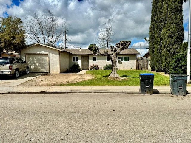 27139 Stanford Ave, Madera, CA 93637 - ranch-style home featuring concrete driveway, stucco siding, fence, a front yard, and a garage