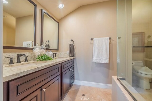 2333 N Coronet Ct, Covina, CA 91724 - bathroom featuring double vanity, toilet, baseboards, a shower with shower door, and vaulted ceiling